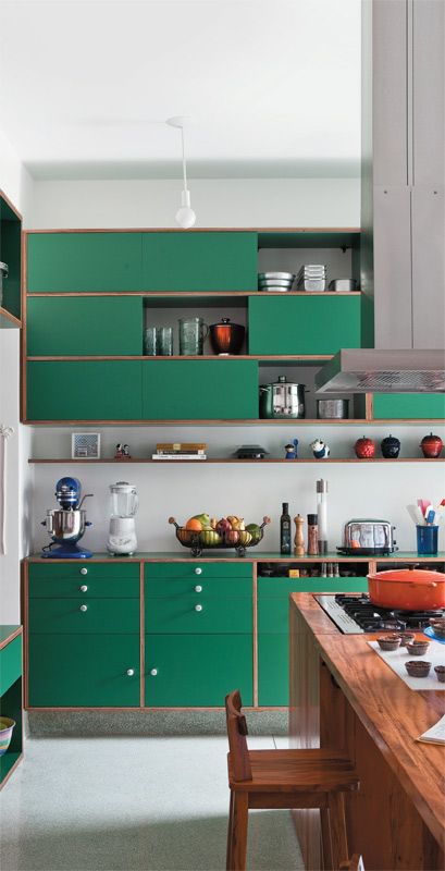 a modern bold green kitchen with copper framing and a grey backsplash looks cute and eye-catchy