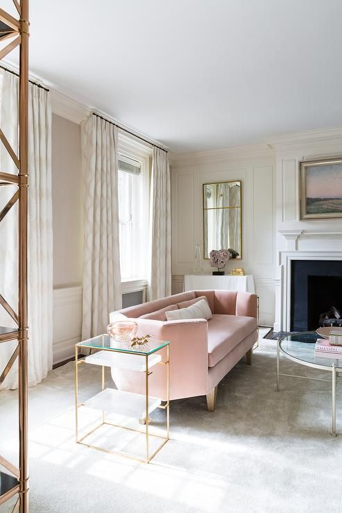 a modern serene living room with a geometric blush sofa and brass touches