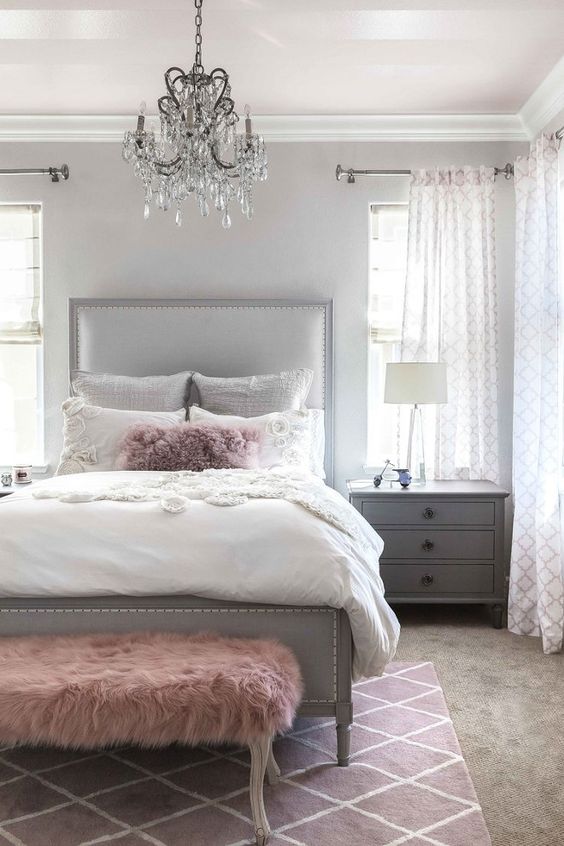 a chic grey bedroom is enlivened with a faux fur dusty pink bench and a matching pillow