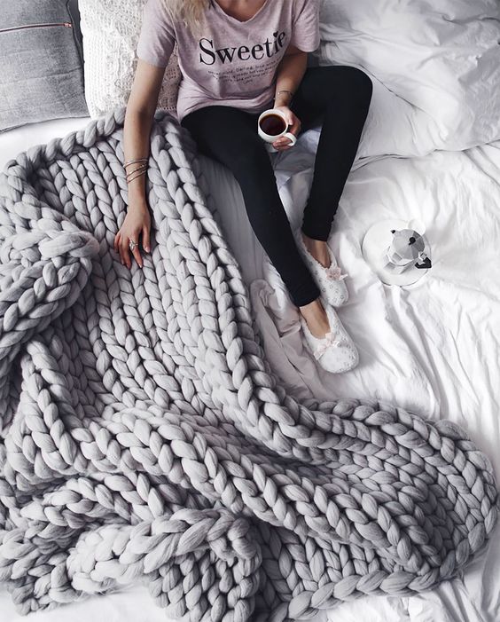 a grey chunky knit blanket will add warmth and a textural touch to your bed