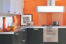 22 an ultra-modern kitchen with black and seehr cabinets and sleek bold orange walls