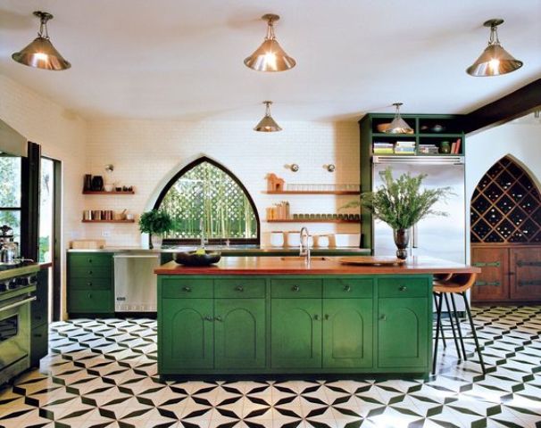 bold green cabinets and a kitchen island are balanced with metalllic lamps and wooden countertops