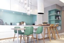 23 a chic kitchen with white cabinets and blue backsplash, green chairs and eye-catchy bubble pendant lamps