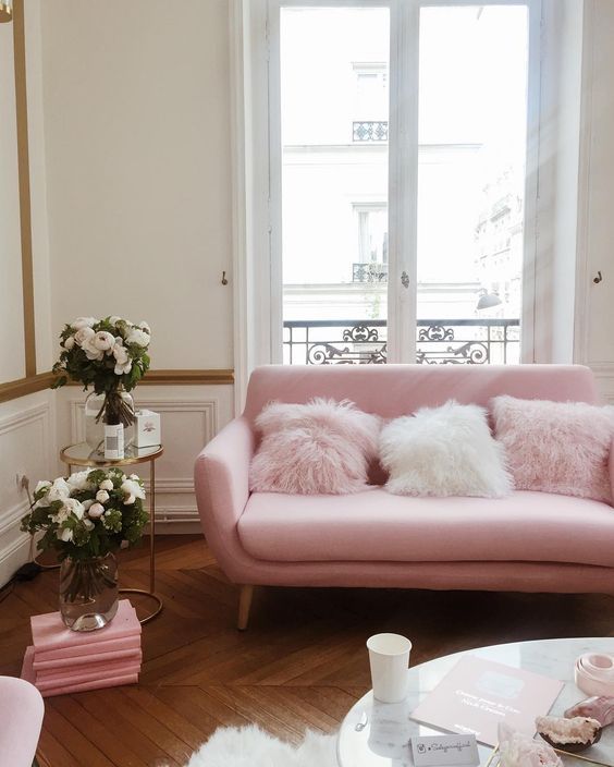 a pink sofa with faux fur pillows makes this space more playful and girlish