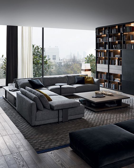 a modern living room done in grey and black, filled with natural light and lots of storage space