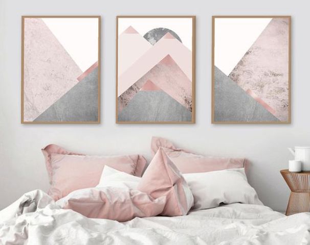 blush pillows and a geometric artwork with blush tones create a soft feel in the bedroom