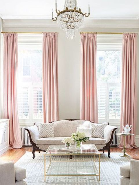 a chic living room with pink curtains and brass touches for a soft feel