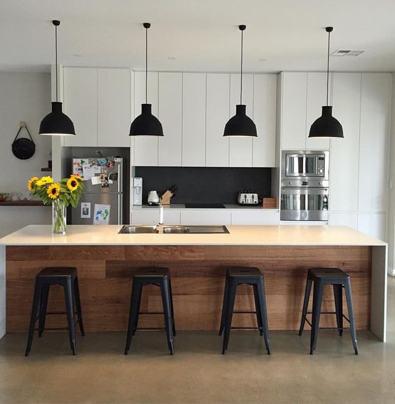 a modern black and white kitchen is spruced up with a wooden kitchen island