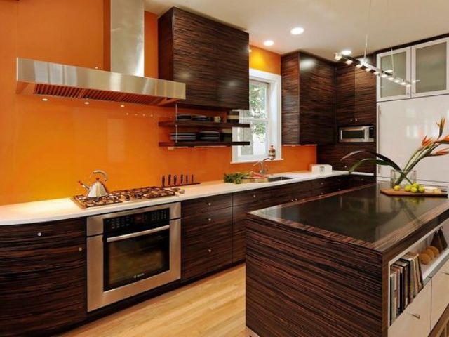 luxurious wood cabinets with bold orange walls for a contrast