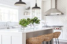26 a chic white kitche with a functional kitchen island and woven stools