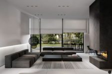 26 a modern moody space with dark furniture, a fireplace and black lamps