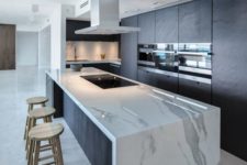 28 a minimalist dark kitchen with a gorgeous large white marble kitchen island for cooking and eating