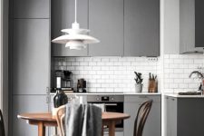 28 a modern grey kitchen with a subway tile backsplash and a wooden dining set for a contrast