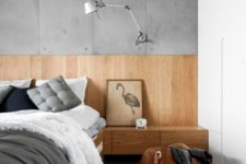 28 a modern light-colored wood wall, platform bed and drawers cozy up the bedroom with concrete panels