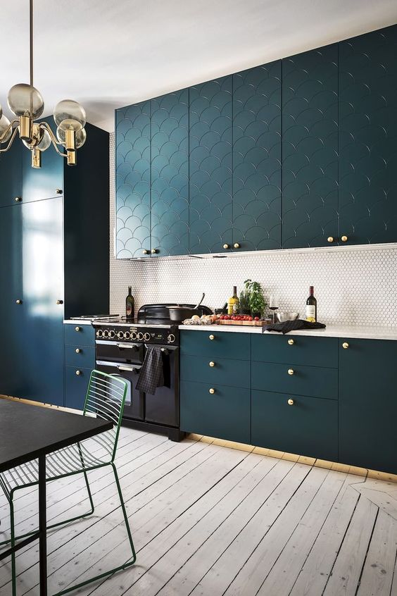 a teal kitchen with patterns, a penny tile backsplash and brass touches for a refined touch