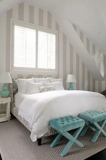 A soft looking guest bedroom with white as the main color, light grey as additional and a couple of turquoise accents
