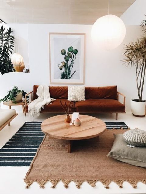 white and cream are taken as main colors, shades of brown and neutral wood add style and softness, and a burnt orange sofa is used for a colorful touch