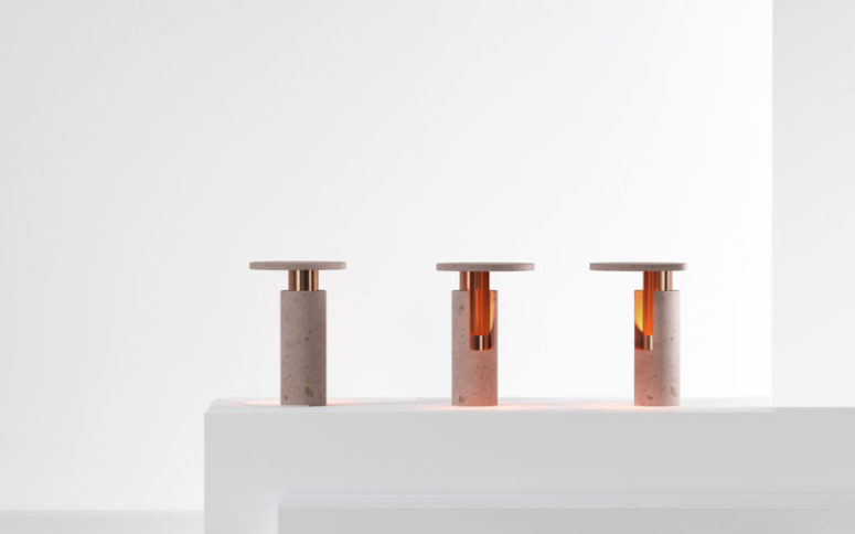 The table lamp features copper cylindrical interior and volcanic rock body in pink