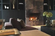 02 a refined moody living room with a built-in fireplace clad with dark metal looks wow