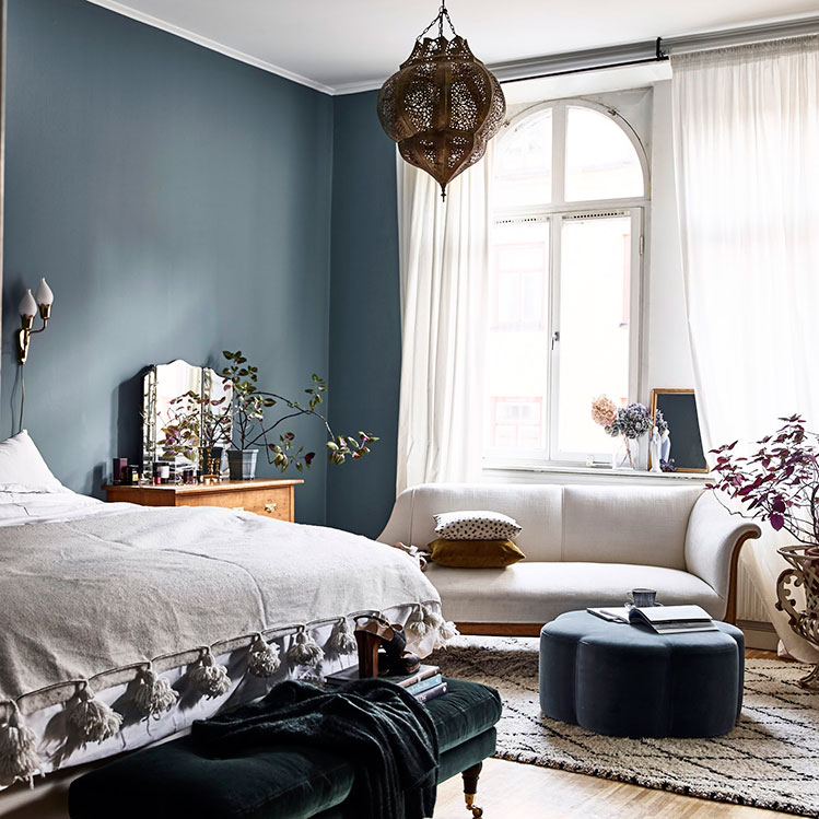 The bedroom is done in Scandinavian blue, with a Moroccan lamp like in the living room, some chic velvet furniture and vintage items