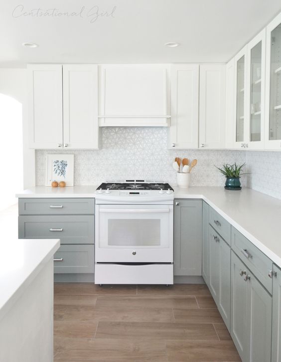 an ethereal kitchen with dove grey and white cabinets and a geometric tile backsplash looks very inviting