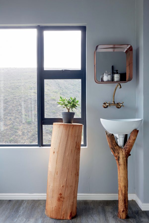 The bathroom features a tree stump stand and a branch sink holder, which remind you that it's an eco cabin