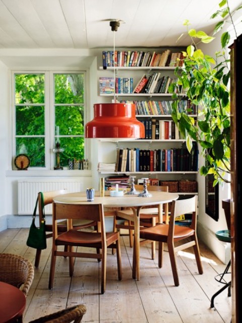 The dining space is done with a wwooden dining set and a round table, a number of bookshelves in the corner stores a lot of books