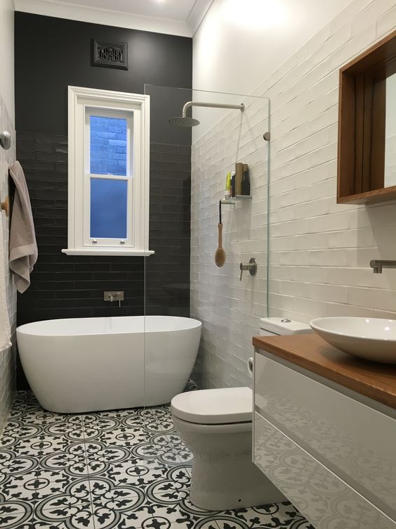 a black tile wall creates a bold contrast and makes the bathtub space stand out