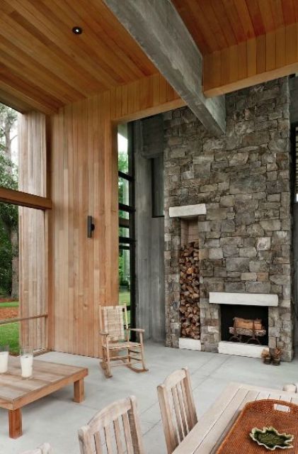 a chalet-inspired retreat features a stone-clad fireplace with firewood storage for an interesting touch