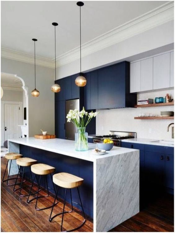 navy and white kitchen with marble countertops, bubble pendant lamps and comfy wooden stools