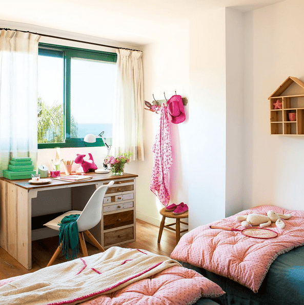 The kids' room is done with bold green and pink, there's a large window to bring light in, and two beds