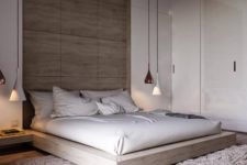 05 a modern space with glossy white walls, a wooden headboard wall, a wooden platform bed and white and copper hanging lamps