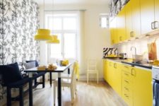 05 a small modern yellow kitchen with dark countertops, a dining zone accentuated with printed wallpaper