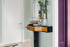 06 The entryway features a bold art deco console table and mirror of a very eye-catchy shape and a geo rug