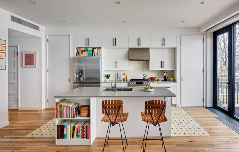 The kitchen is a neutral one, with metallic surfaces and lots of books, it's filled with natural light
