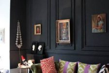 06 a black panel wall makes a statement in this space, with neutrals and muted colors, a green sofa and refined artworks