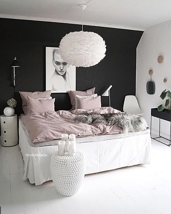 a girlish bedroom is calmed down with a black headboard wall, which stands out in this neutral space with blush touches