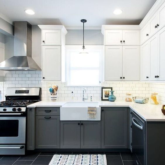 a graphite grey and white kitchen with stainless steel appliances and black knobs for a chic monochromatic look