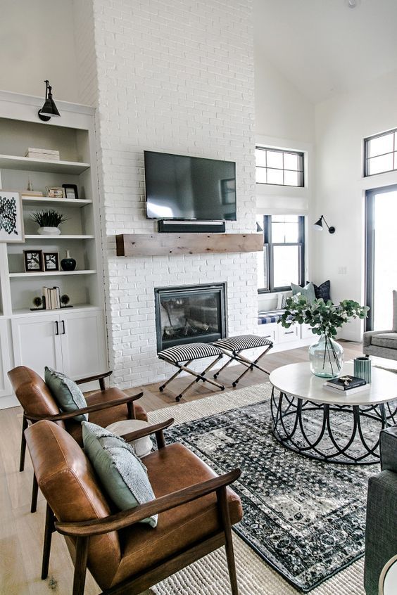 A neutral space with a boho feel, a built in fireplace in a whitewashed brick wall