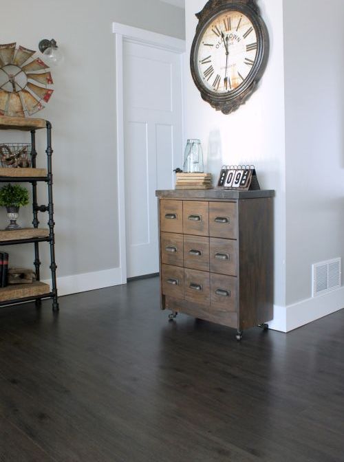 A small reclaimed wood apothecary cabinet placed on casters as a cute and eye catchy entryway console