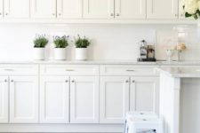 06 a vintage white kitchen with a white tile backsplash, stools and much storage space