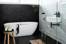 06 large scale black hex tiles cover the floor and go up the wall and contrast the white tiles