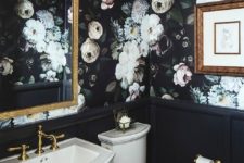 06 moody realistic floral wallpaper gives a tone to this vintage powder room, and there’s a gilded mirror and black paneling