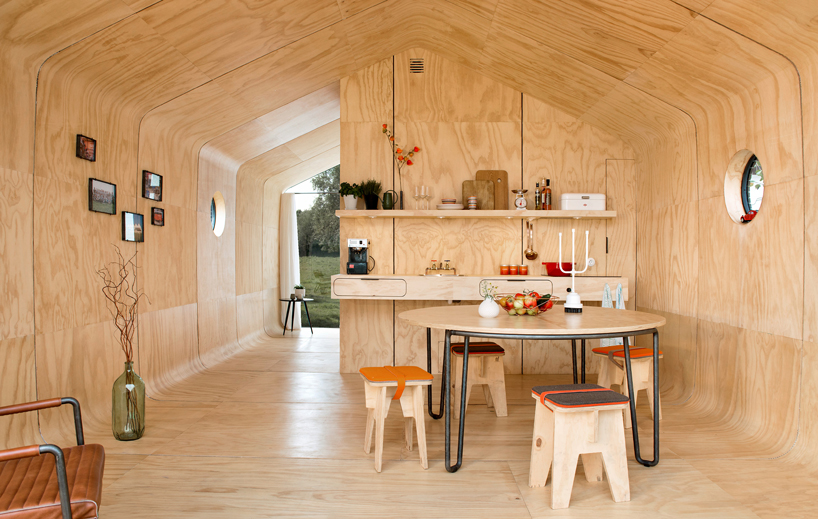The inside is covered with plywood, there's a small kitchen, a dining space, some shelves