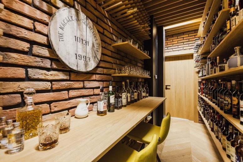 There's a stylish wine cellar with bricks, shelves and colorful chairs for comfortable tasting