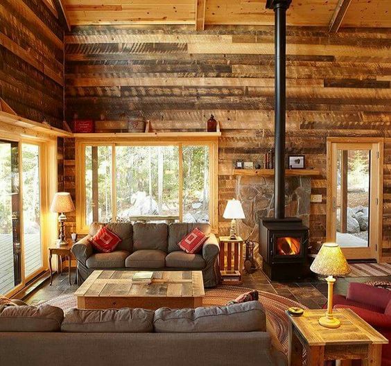 a cabin living room with reclaimed wooden walls and furniture for a cozy feel