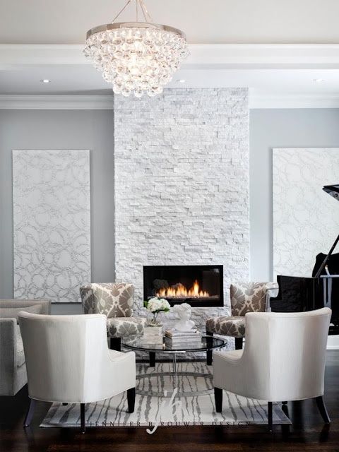 a glam neutral space with a white stone clad fireplace for a chic refined look