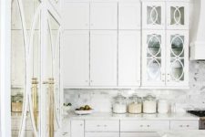 07 a gorgeous white kitchen with brass details and mirror and glass doors looks really luxurious