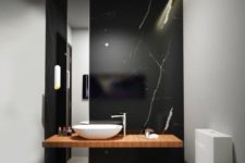 07 a refined black marble wall with white veins as a statement feature in a minimalist bathroom