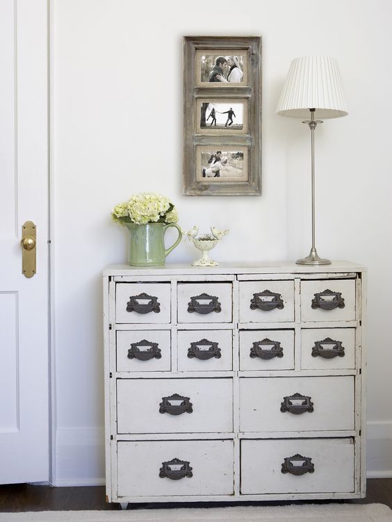 a vintage cabinet painted white with refined handles as a chic entryway console
